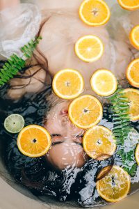 Woman bathes in bath with sliced fruit to improve her skin