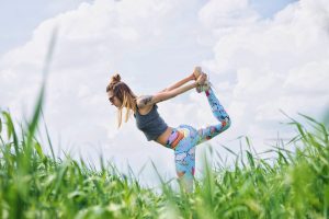 Woman in a field doing healthy stretching before she exercises