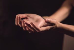 Woman holds hands out to inspect her skin