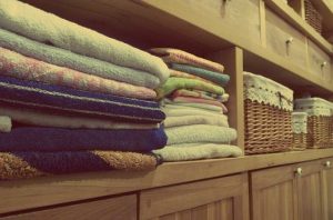 Inside a wardrobe with shelves all neatly organised with baskets and drawers after spring cleaning