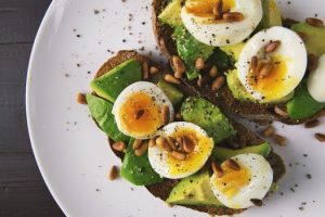 Plate of boiled eggs and spinach on whole wheat toast as part of a healthy diet