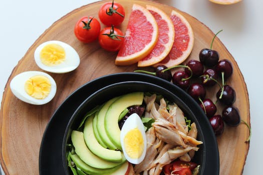 Plate of fruit, eggs, vegetables and chicken as part of a healthy diet